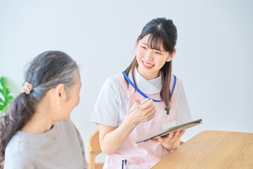 会話するシニア女性とエプロン姿の若い女性