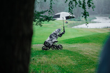 Golf bag with clubs stands on field in rain