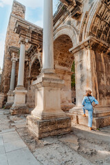 Tourist woman at Hadrian's Gate in Antalya Turkey during summer day.