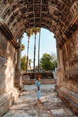 Tourist woman at Hadrian's Gate in Antalya Turkey during summer day.