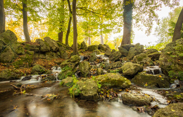 kleiner Felsen-Wasserfall in herbstlichem Wald