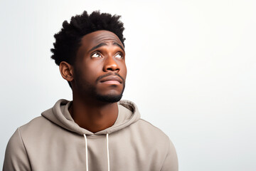 Upset and hopeless young man with African appearance on white isolated background - obrazy, fototapety, plakaty