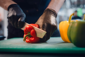 Koch schneidet Gemüse in Küche