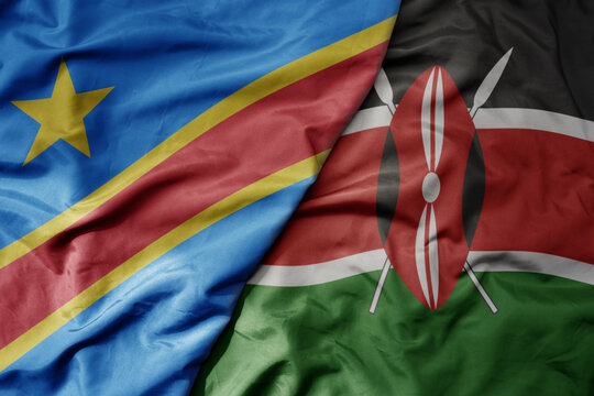 big waving national colorful flag of democratic republic of the congo and national flag of kenya .