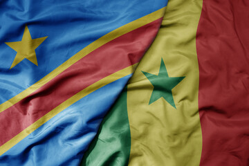 big waving national colorful flag of democratic republic of the congo and national flag of senegal .