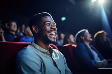 man laughing while watching a comedy show