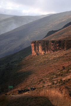 A dried and hazy Peruvian landscape vertical with a sign of Palcamayo road in Tarma, Junin, Peru