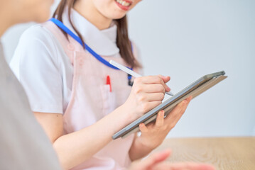 シニア女性の話を聞くエプロン姿の若い女性
