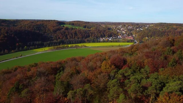 Drone flying over typical bavarian rural landscape in autumn with colorful leaf tree foliage