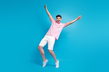 Fototapeta na wymiar Full length photo of positive delighted man raise arms unbelievable news isolated on blue color background