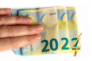 2024 written with euros bank notes in a hand isolated on white background, new year greetings money concept