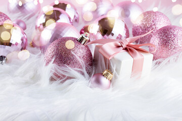 Pink Christmas decorations on white fur background