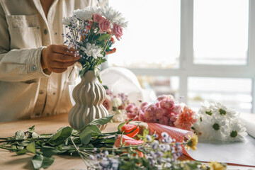 Florist at work. Woman making autumn floral decorations