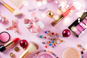 Festive make up products on pink flat lay background