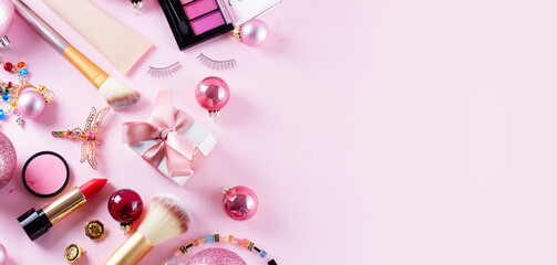 Festive make up products on pink background banner with copy space