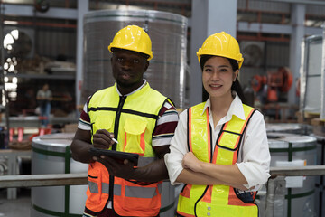 Warehouse of raw materials. Rolls of metal sheet, aluminum material. Male and female factory worker at aluminum material warehouse