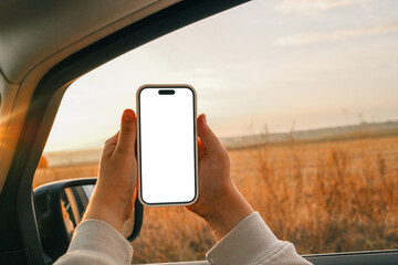Phone in hands with an isolated screen on the background of an autumn road