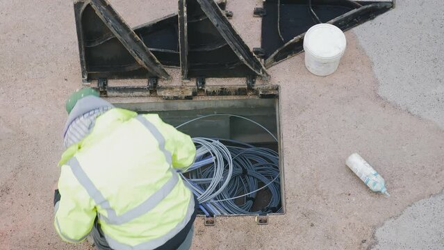 telecommunication technician proceeds with the cabling of fibre optic cables. In particular, individual fibre optic cables are pulled out of the protective sheathing
