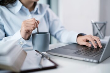 Asian Woman working by using a laptop computer Hands typing on keyboard. Working at office professional investor working new start up project