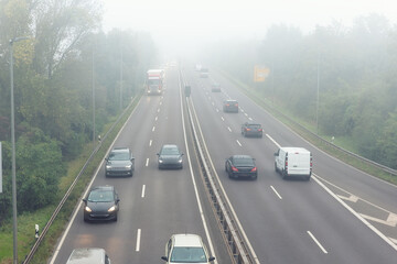 Scenic city highway road traffic jam many cars at foggy misty rainy haze morning low poor...