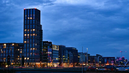 Fototapeta premium Szklane wieżowce wieczorną porą przy rzece Liffey w miejscowości Dublin w Irlandii