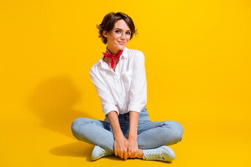 Photo of positive pretty girl wear trendy outfit eyewear sitting floor isolated on yellow color background