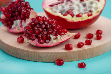 Several ripe pomegranate fruits and an open pomegranate, pomegranate on table, top view, dark...