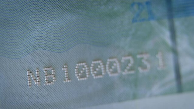 Number in the passport with visible degrees of protection against counterfeiting. Passport page under ultraviolet light. Passport of the Kingdom of North Barchant. Document of the virtual state.