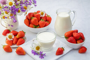 summer breakfast concept. tea, strawberries on a served table and lilacs