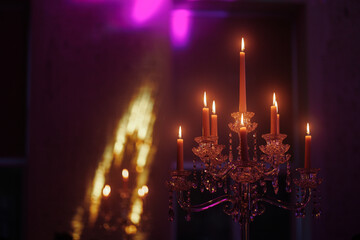 Candelabra with candles in a purple backlit background. Creepy or romantic atmosphere concept.