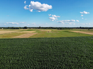 Beautiful agricultural landscape, open field with blue sky and white clouds. Farmfields from a bird's eye view.