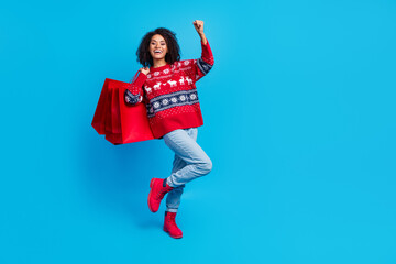 Fototapeta na wymiar Photo of excited carefree girl wear stylish print sweater rejoice seasonal low price gifts empty space isolated on blue color background