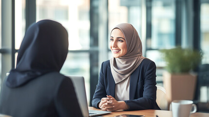 smiling middle eastern business woman with hijab talking with client