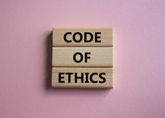 Code of ethics symbol. Concept words Code of ethics on wooden blocks. Beautiful pink background. Business and Code of ethics concept. Copy space.