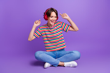 Photo of carefree cheerful funky girl dressed trendy clothes listening playlist hit sound isolated on violet color background