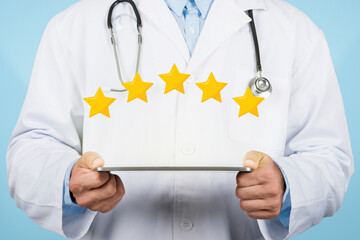 Doctor man holding tablet displaying five-star rating, blue background
