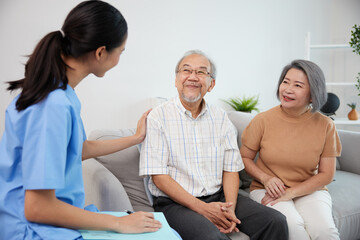 nurse or caregiver meeting and talking with about health with senior couple