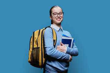 Portrait of teen girl high school student on blue studio background