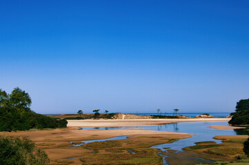 Coastal landscape with sand dunes and blue sky, Spain.