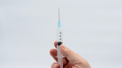close-up of a hand holding a syringe with medicinal liquid ready to be injected


ment
