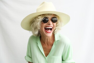Joyful woman in green outfit, classic glasses, laughing and having fun in photo studio