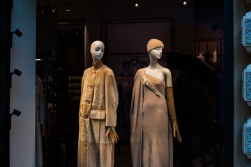 Naklejka premium Fancy clothing in a store in European shops. Display of a clothing store, bright and fashionable window of modern fashion. Beautiful fur clothing in a luxury store window.