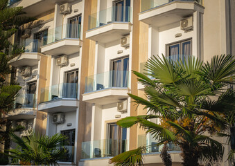 Apartments. Buildings facade exterior with windows and balconies, palm trees, real estate property architecture - obrazy, fototapety, plakaty