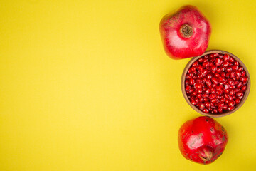 Several ripe pomegranate fruits and an open pomegranate, pomegranate on table, top view, dark...