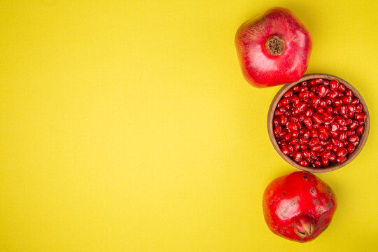 Several ripe pomegranate fruits and an open pomegranate, pomegranate on table, top view, dark background, Fresh ripe pomegranate on black background, selective focus, Healthy pomegranates fruit garnet