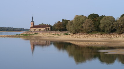 Paysage au lac du Der Chantecoq, en Champagne Ardenne, dans la région Grand Est, avec l’église de Champaubert et des arbres se reflétant dans l’eau (France)