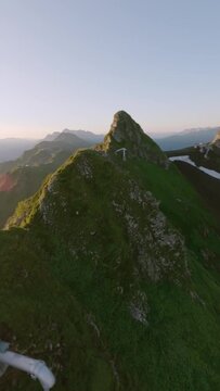 Vertical video. Aerial view sunny mountain range valley running alpine goat wild animal in morning sun. FPV sport drone shot picturesque geology formation landscape industrial tube gazex majestic 4k