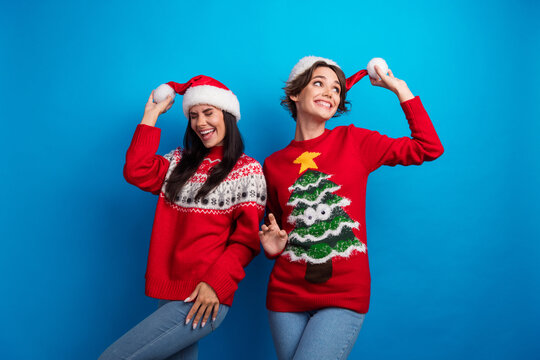Photo of positive girls dancing enjoy december winter x mas ads promo isolated blue color background