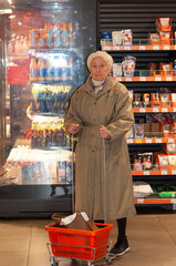 Senior adult female is shopping at a grocery store. She is reading nutrition facts on the label. She is shopping alone.