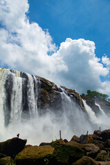 The sight of white clouds falling to the ground like a waterfall, A waterfall cascading down to earth through sky-high mountains, Athirappilly, Kerala  India